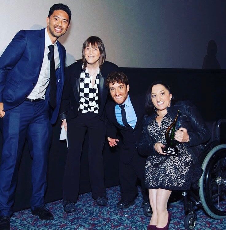 A group photo of Nicole Evans and friends at an event.
