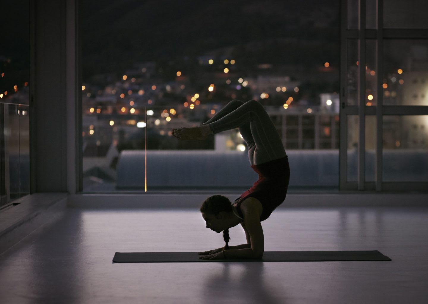 Woman stretching on yoga mat, at sunset