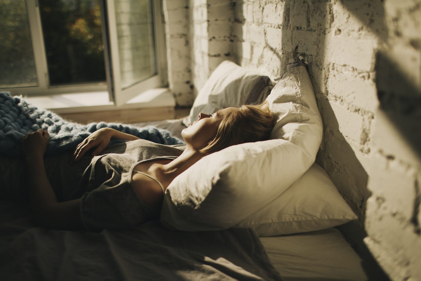 A woman lying in her bed and sleeping. habits and routines, improving productivity, healthy lifestyle, rest and recovery, GamePlan A