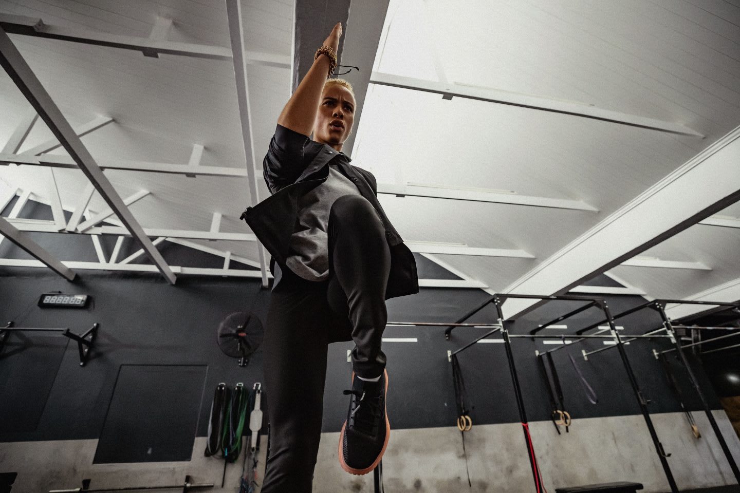 Woman training in a gym, she is sprinting on the spot using high knees.
