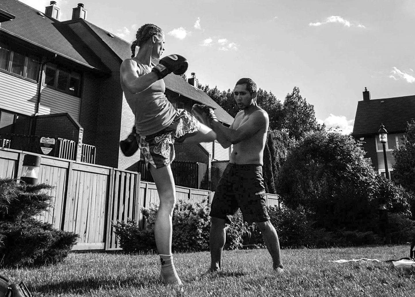 a women and a man kickboxing in a backyard