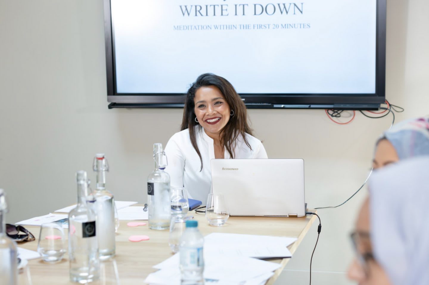 A women presenting in front of a screen to a group of women. Experience with depression, nazia, women, business, coaching, work, mental strength, mindfulness, GamePlanA