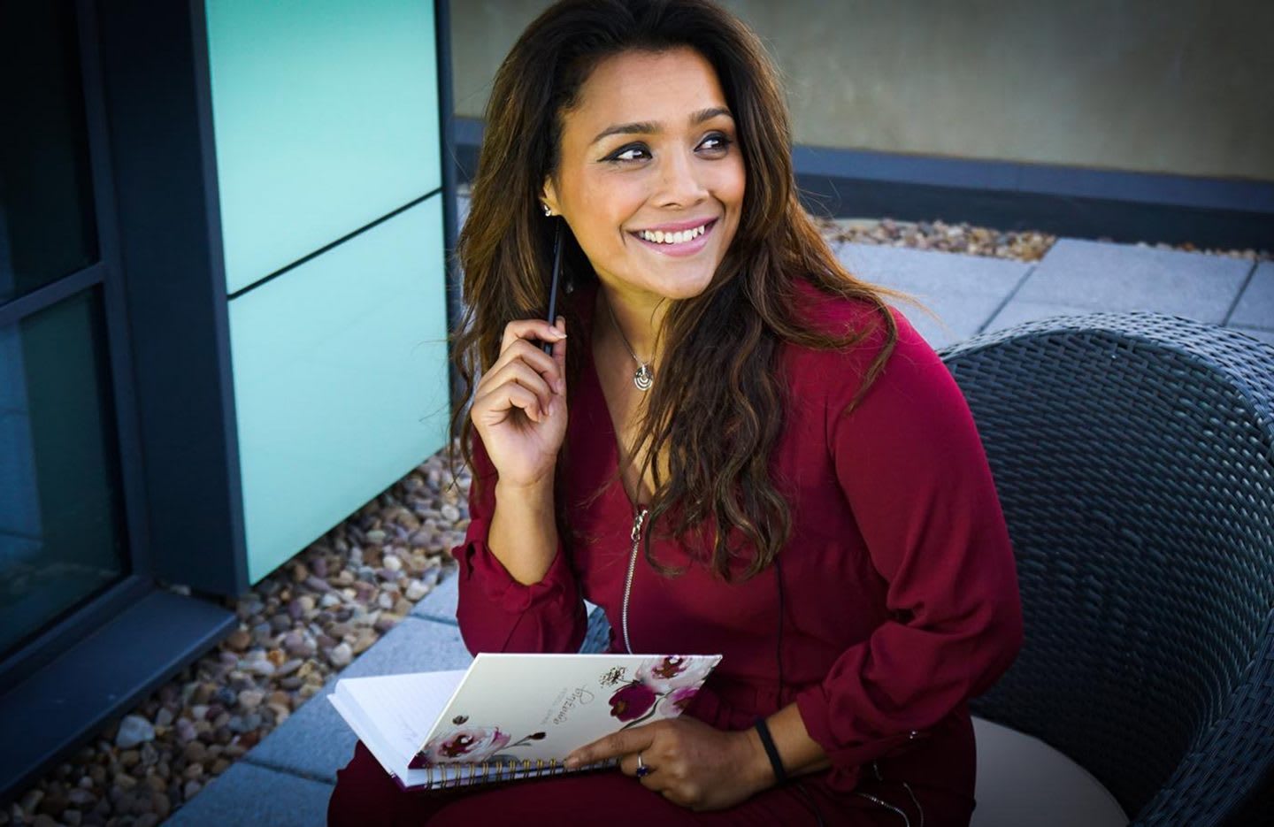 A women laughing while writing ideas into a notebook. mental wellbeing, habits and routines, health, mental strength, healthy lifestyle, GamePlanA