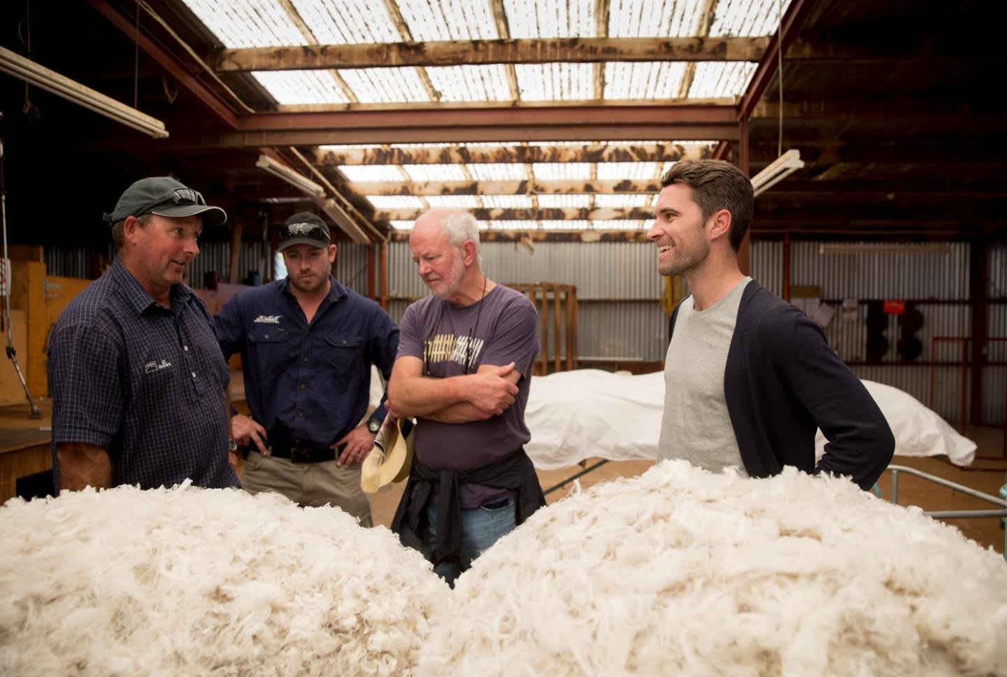 Men talking in a wool factory and smiling, Tim Brown, CEO, Allbirds, sustainability, sustainable, eco-friendly, wool, material, New Zealand