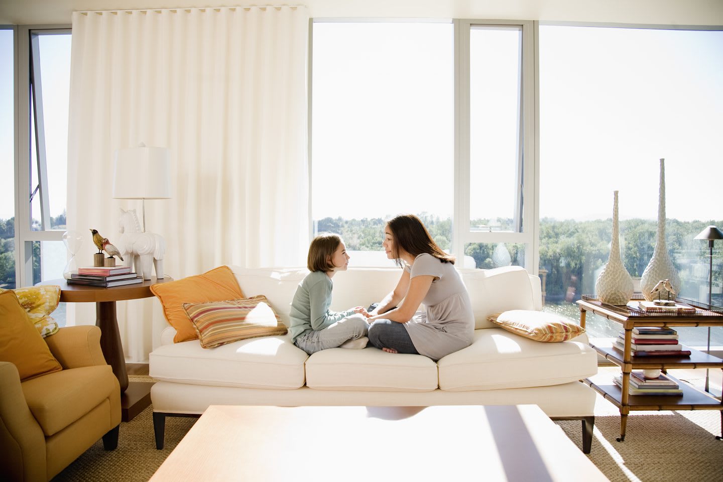 Mother and child having a conversation while sitting on the couch in a light flooded apartment. Purpose, purpose driven life, joy, GamePlanA.