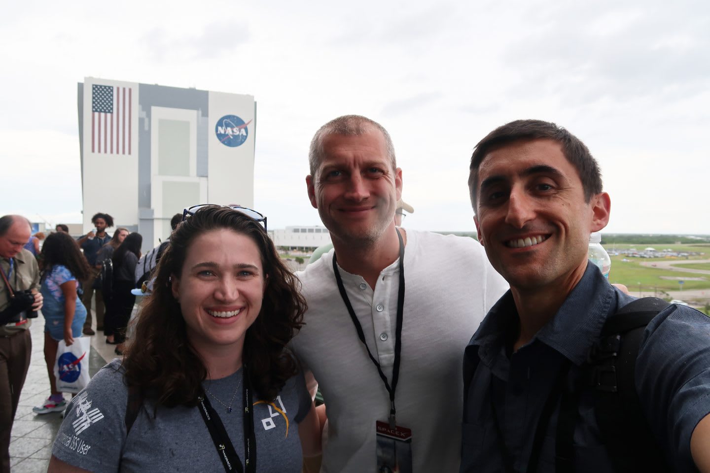 Two men and one woman standing together smiling in a group at NASA, spaces, ISS, sports, collaboration, teamwork, adidas, Nanorocks