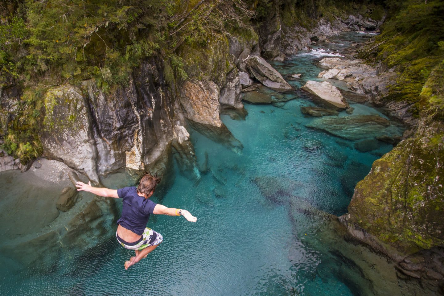 The Blue Pools of Makarora offer enticing blue waters to swim in. A man jumps off a bridge into the water, risk, unknown, leaping, confidence, GamePlan A