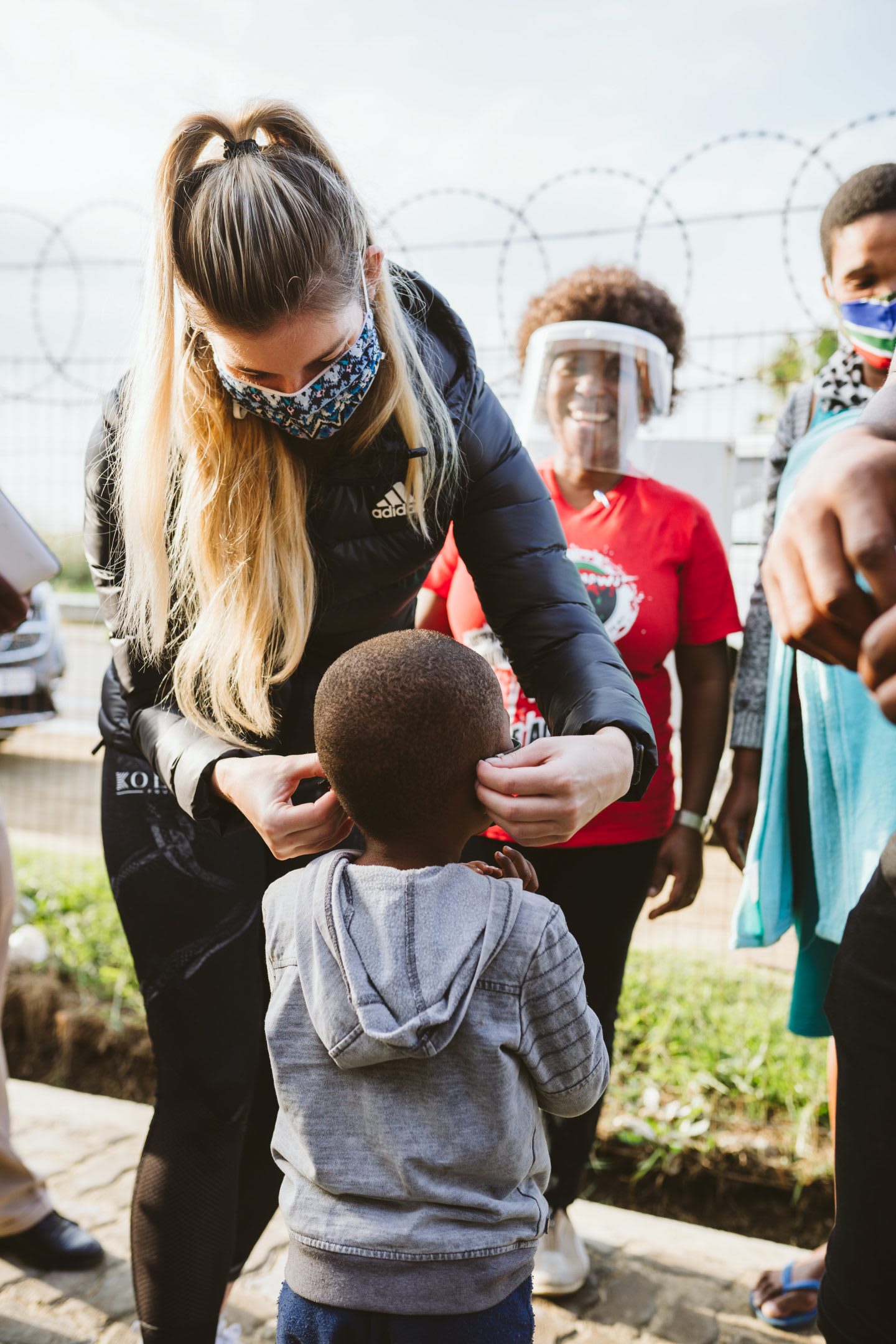 Rachel Kolisi putting a mask on a child in South Africa during coronavirus pandemic, volunteering, help. donation, Kolisi Foundation, South Africa