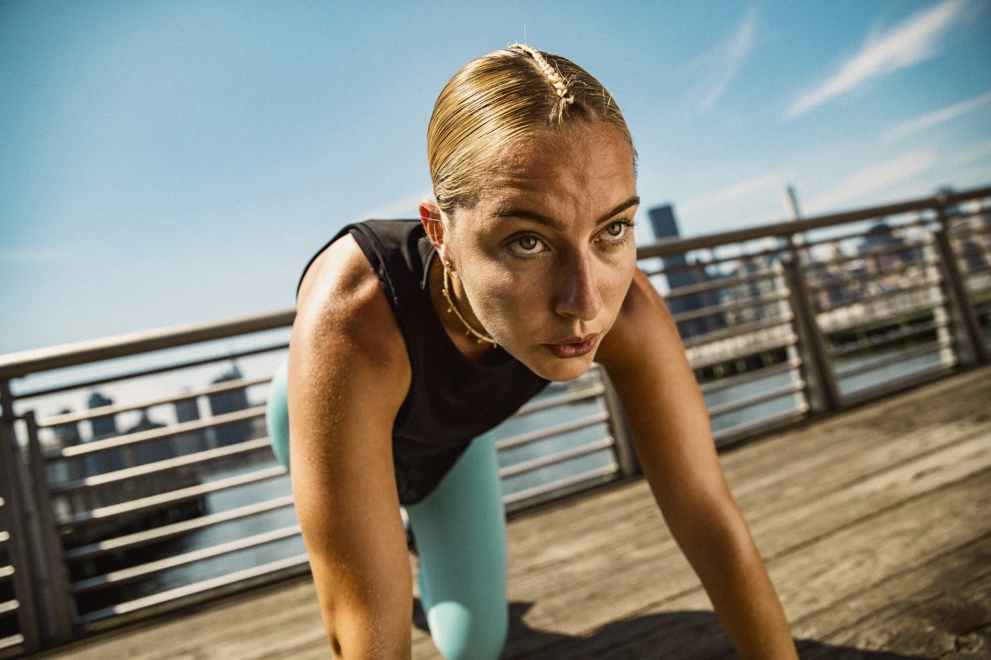 Woman looking focused and determined while doing sports on a boardwalk near a city, skyline, active, sport, lifestyle, mindset, adidas, female, athlete