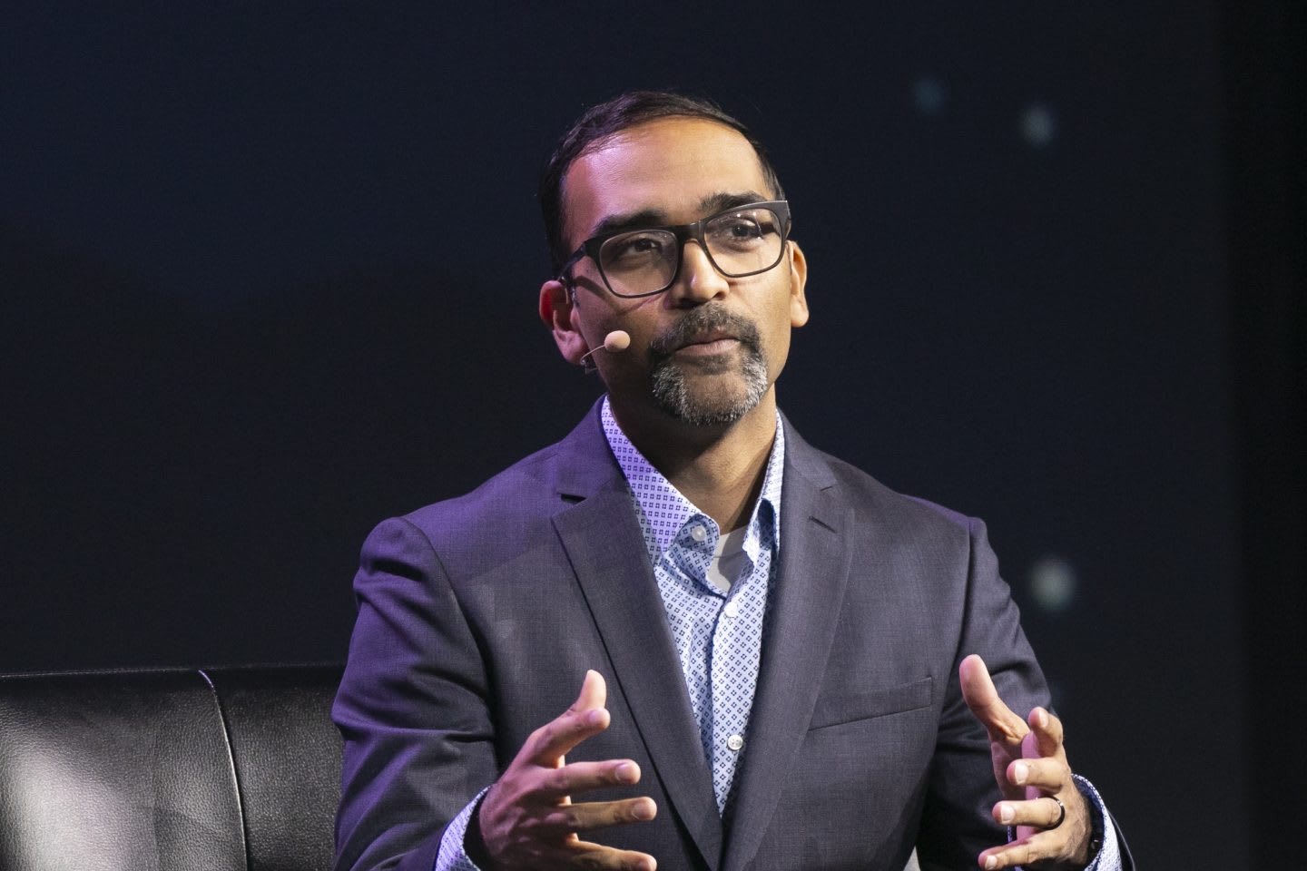 Man wearing suit speaking on stage during conference, business, expert, Ryan Patel