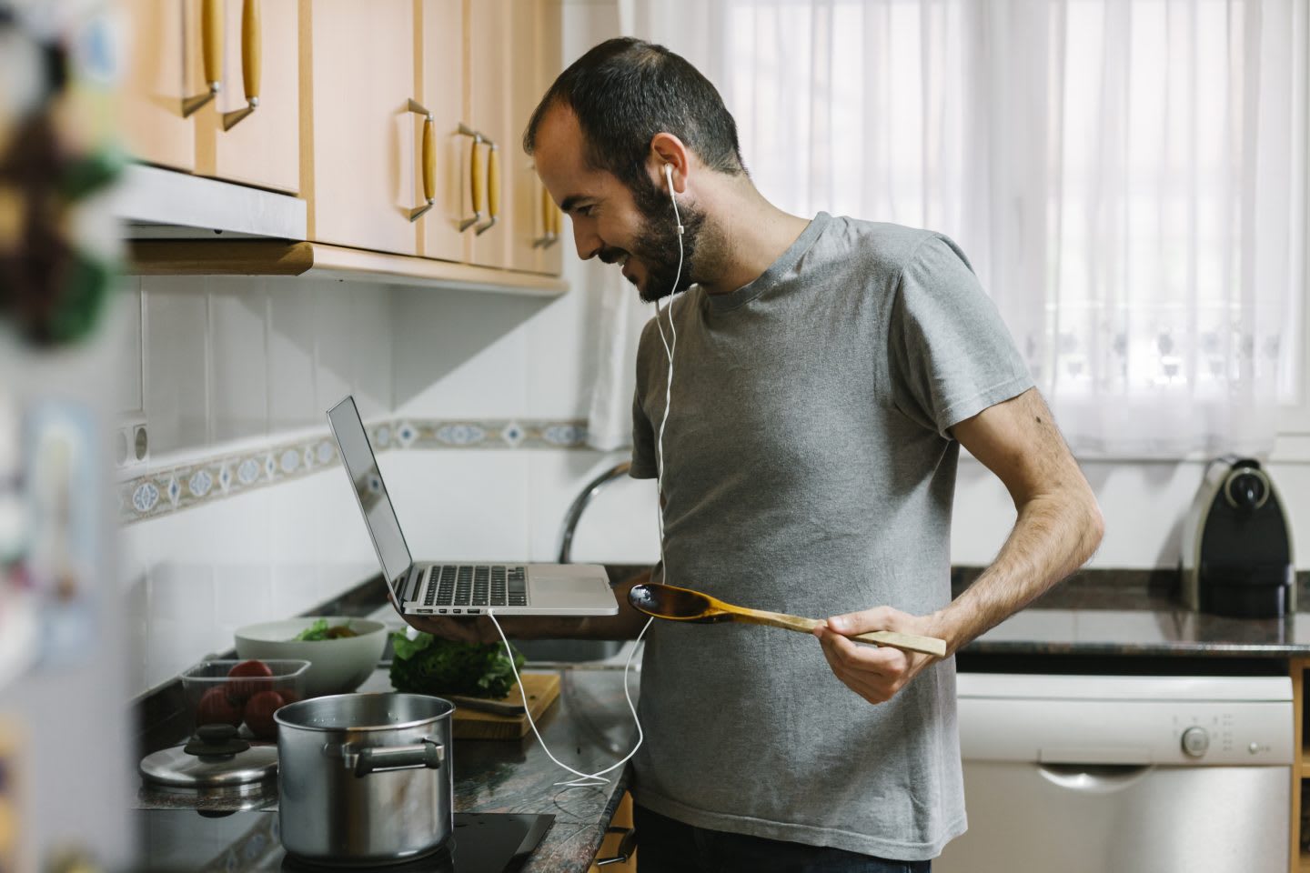 Man cooking while working from home, remote work, telework, telecommuting, teleworking