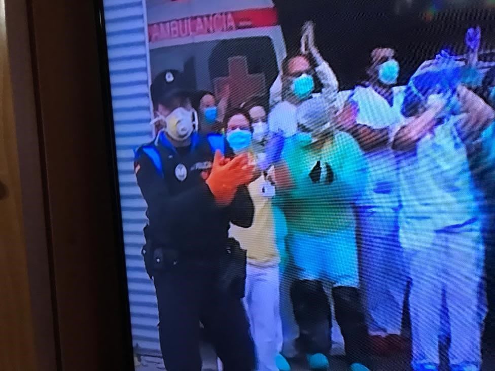 Television screen of healthcare workers showing appreciation and clapping for each other during coronavirus pandemic, COVID-19, corona, healthcare, hospital, nurses, Sara Baeza, Madrid, Spain