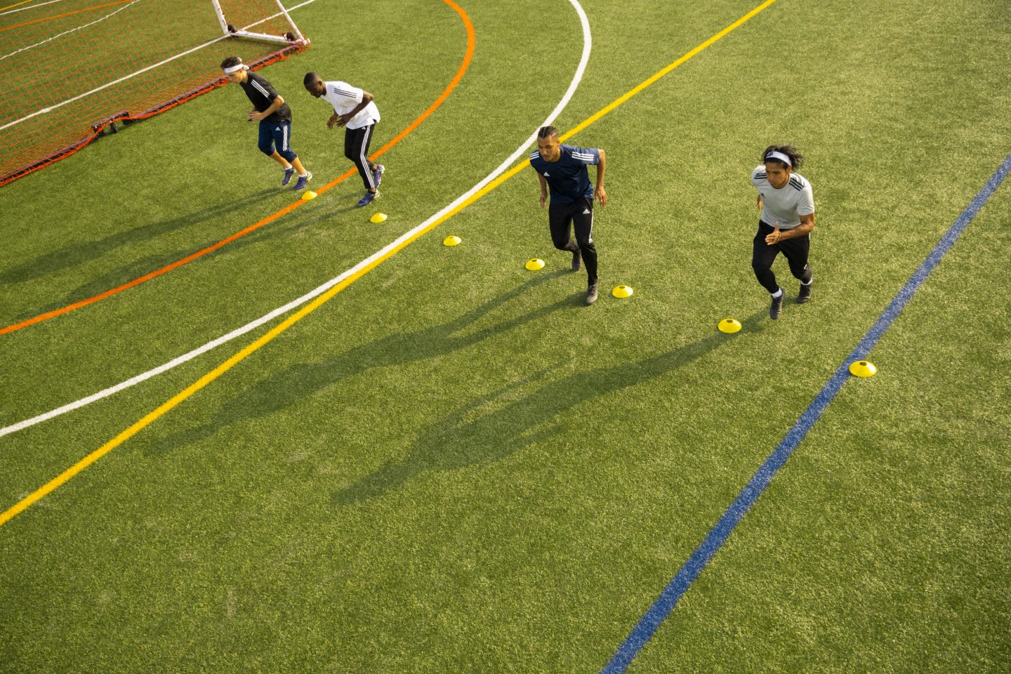 Men lining up on a football field to perform football drills, soccer, football, sports, exercise, fitness, adidas
