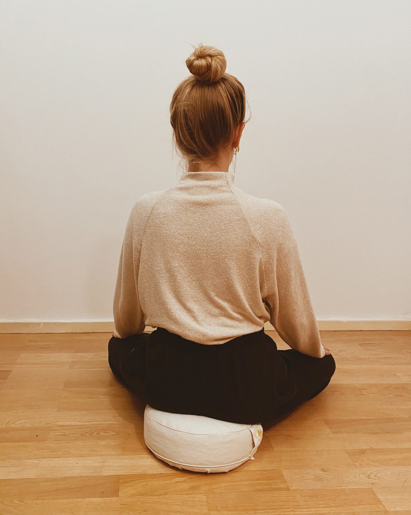 Blonde girl sitting in meditation pose with eyes closed on the floor, meditation, focus, mindfulness, Vipassana
