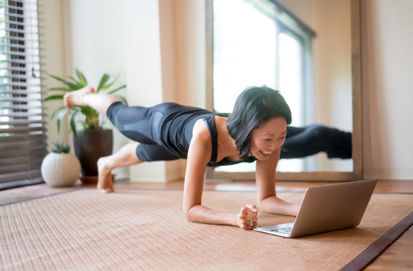 Asian woman exercising at home following a fitness video online. exercise. fitness, sport, virtual