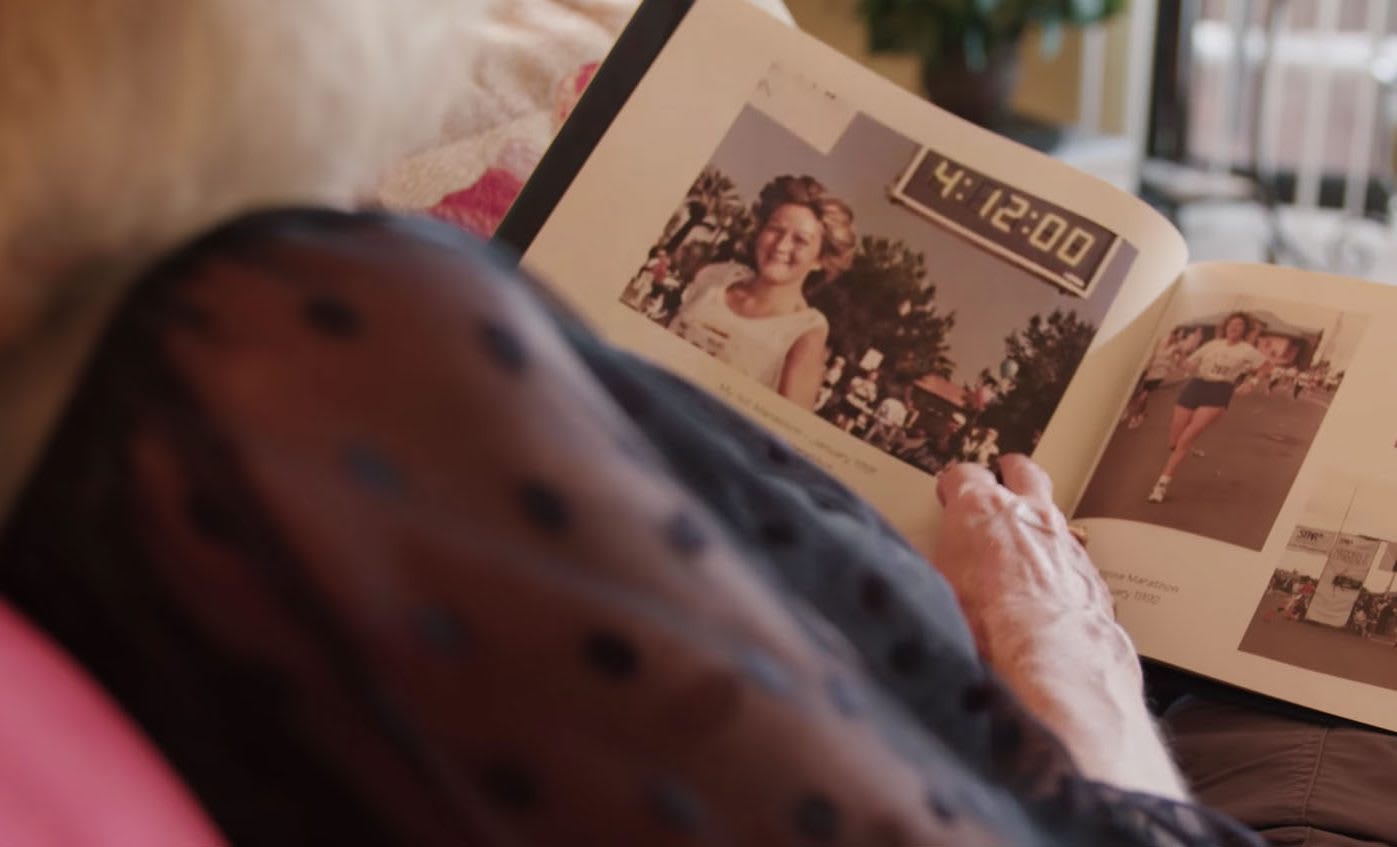 Older woman looking at old picture of herself in a scrapbook, picture, memory, EXOS