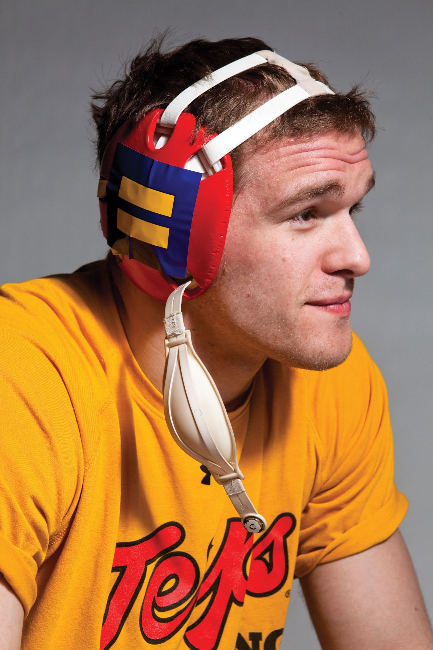 Man in yellow t-shirt wearing wrestling head gear, protection, sports, Athlete Ally, Hudson Taylor, founder