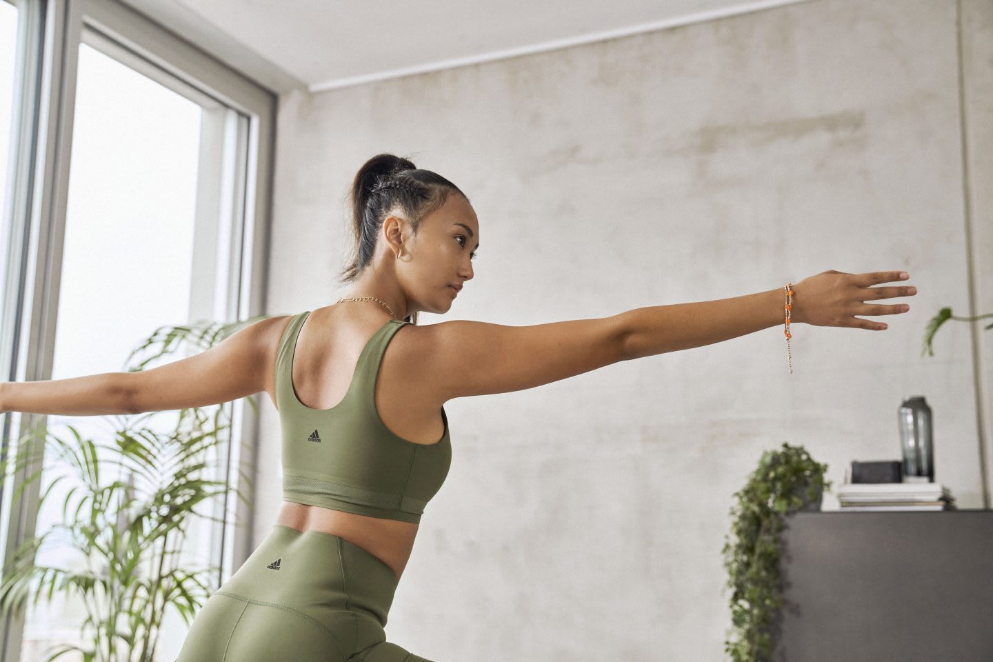 Woman in green yoga outfit in a yoga studio practicing yoga, healthy, lifestyle, stretching, exercise, fitness