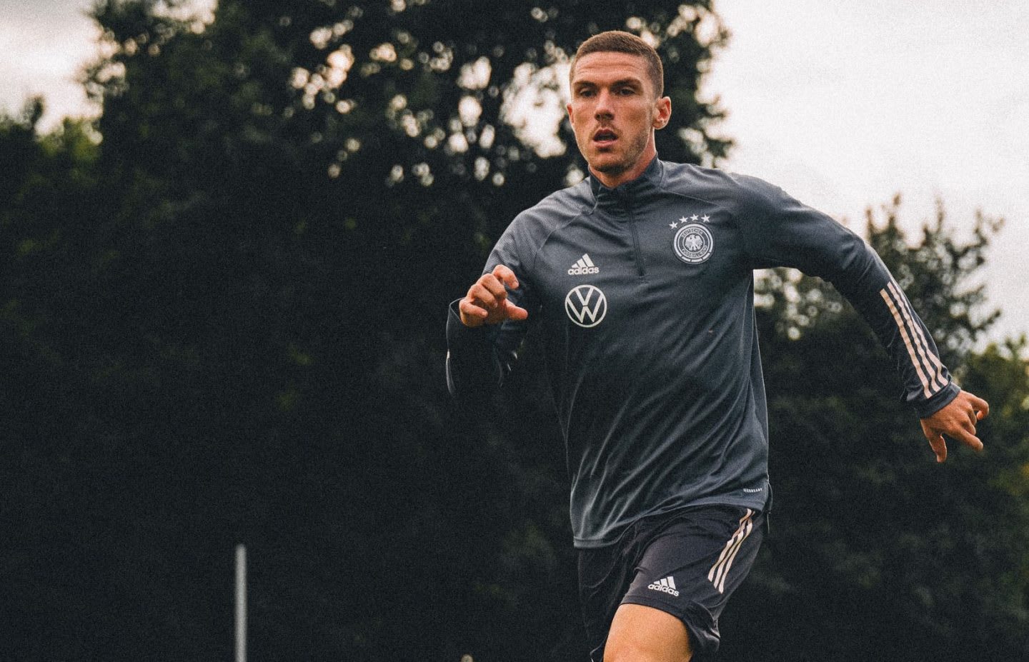 Caucasian man running and kicking a footballer on a grassy pitch, Robin Gosens, footballer, football, German, Germany, team, adidas, sports, exercise, DFB
