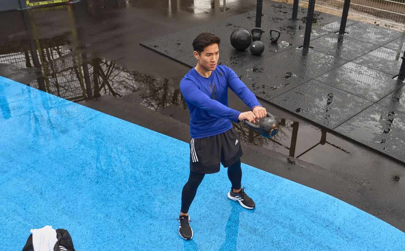 Man wearing blue sports shirt working out with kettlebell, gym, outdoor, sports, fitness