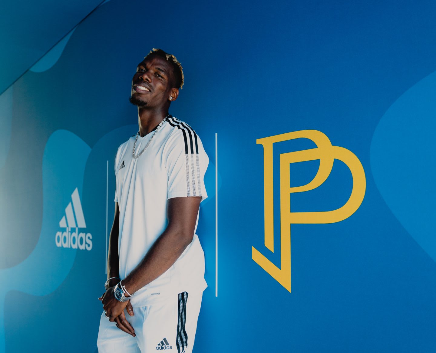 Paul Pogba standing on a wall painted with his logo. Football, legend, adidas, star,, playing football