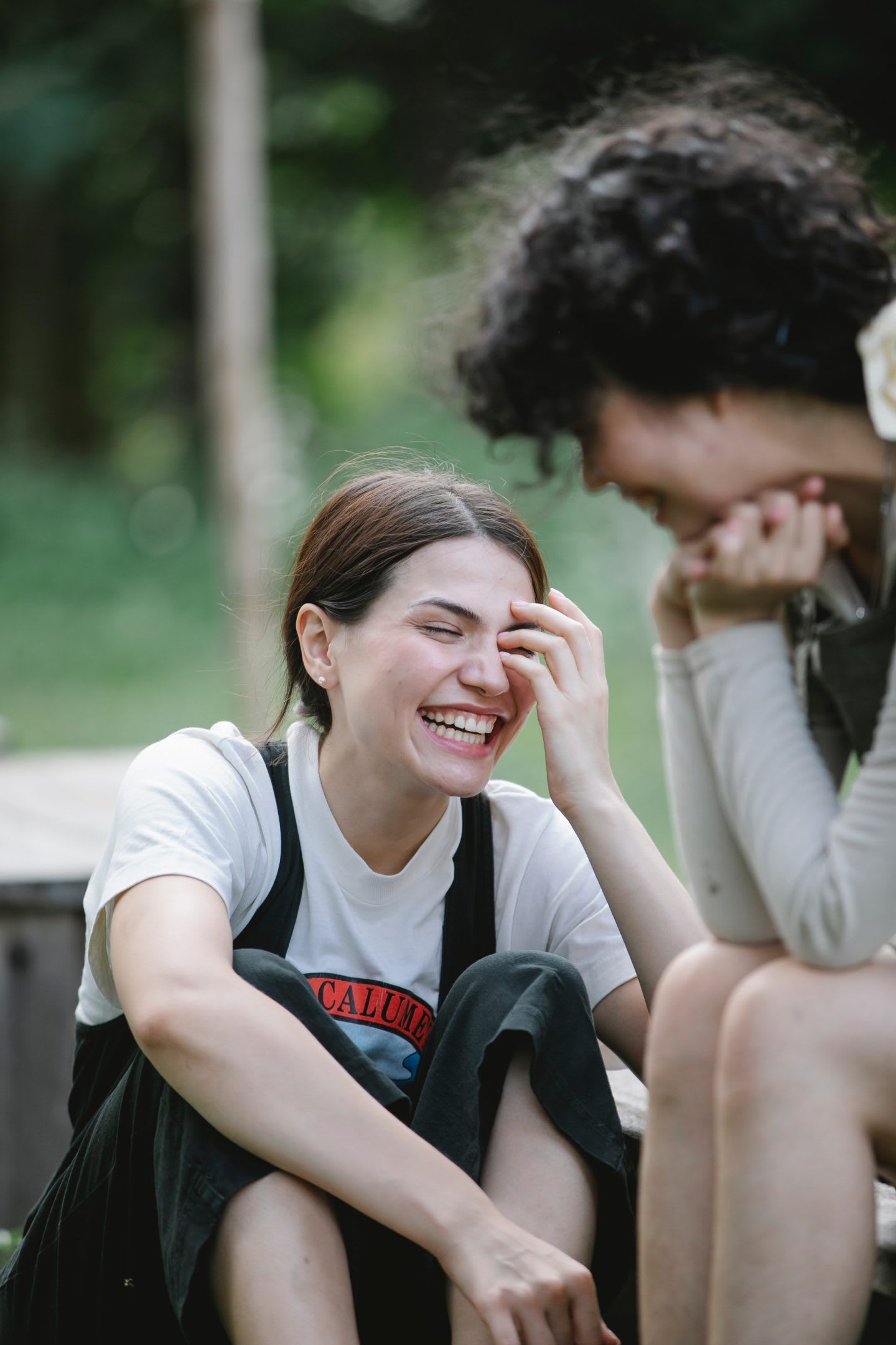 Girls laughing while talking to each other, socializing, friends, happiness, young, students