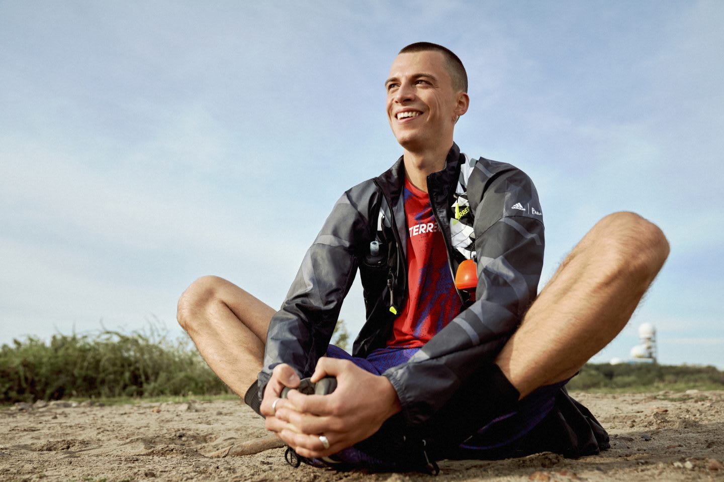 Man smiling in the outdoors while doing butterfly pose, stretching, sports, sport, fitness, adidas
