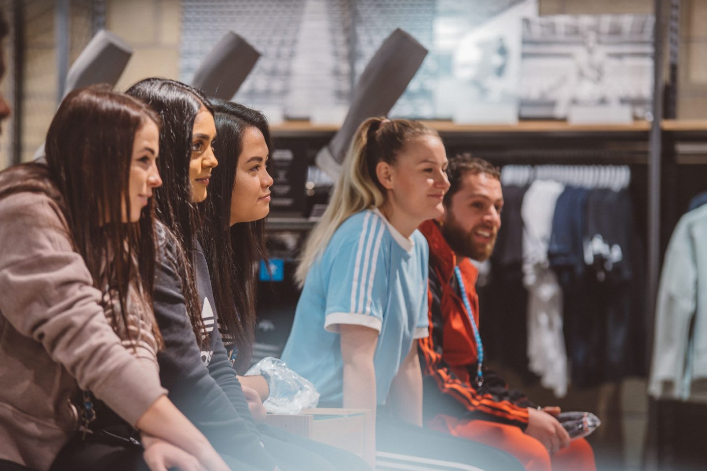 Women and men sitting together listening to a speech, adidas, employees, retail, store