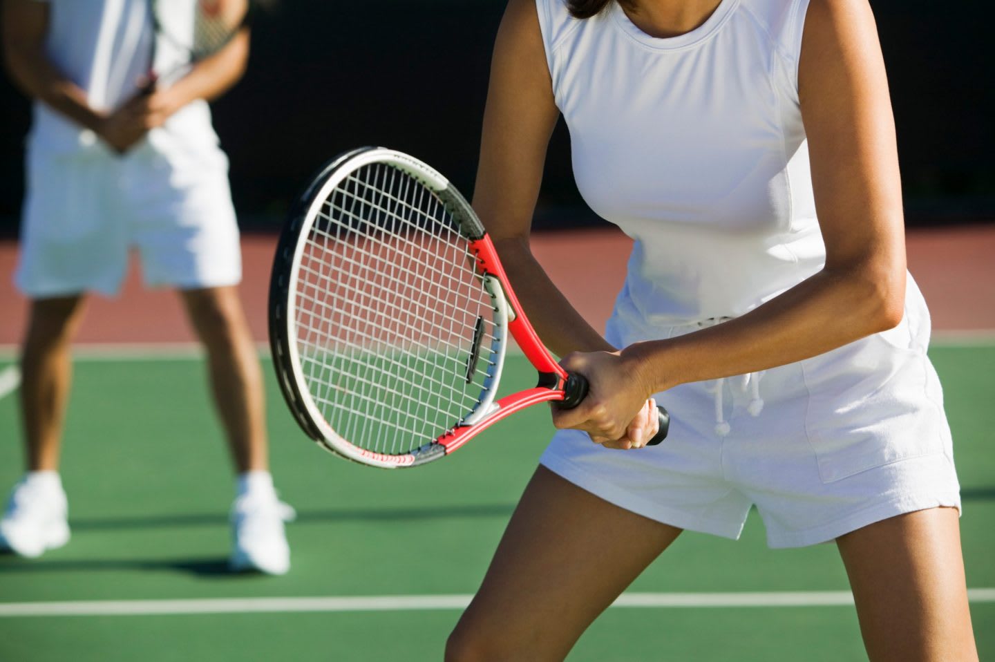 Woman wearing tennis whites holding a tennis racket during a doubles game, sports, sport, tennis, players