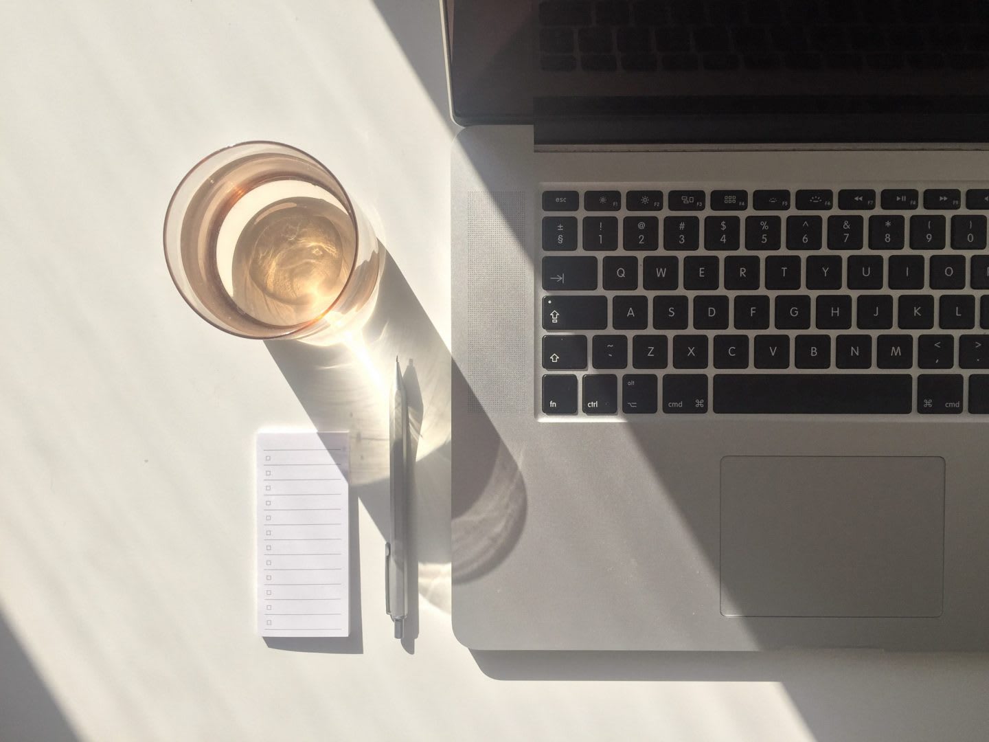 Desk with sunlight with laptop, glass of water and stationary, hydration, work, laptop, notepad