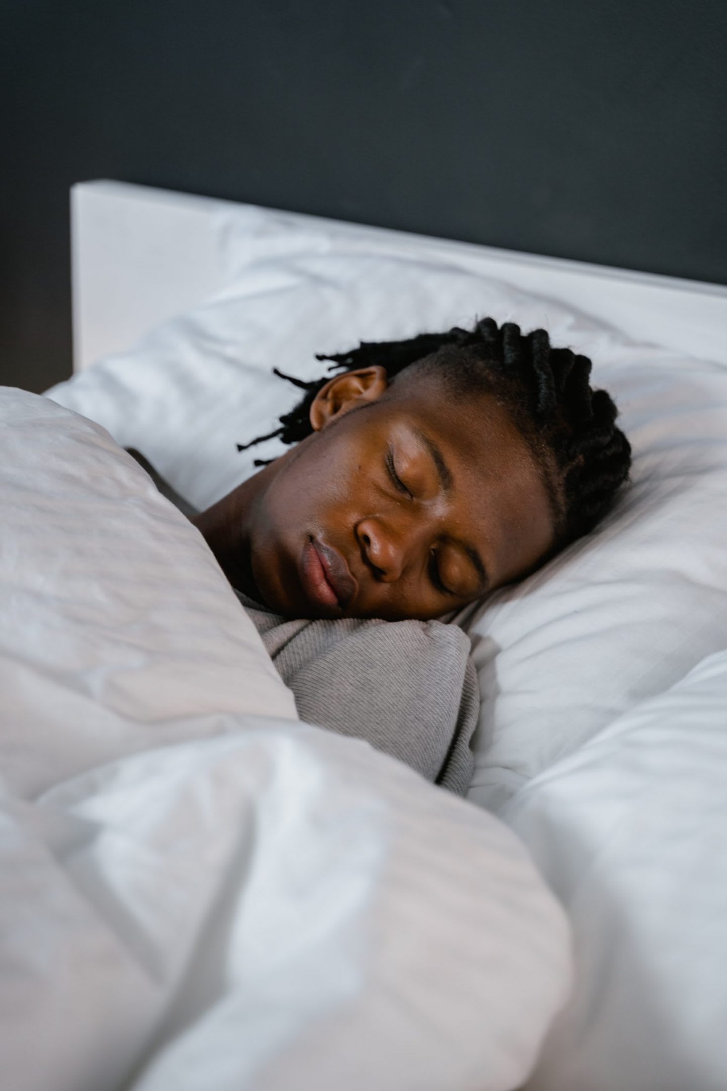 Man sleeping in a bed with white bedsheets, sleep, recovery, rest, comfortable, bed