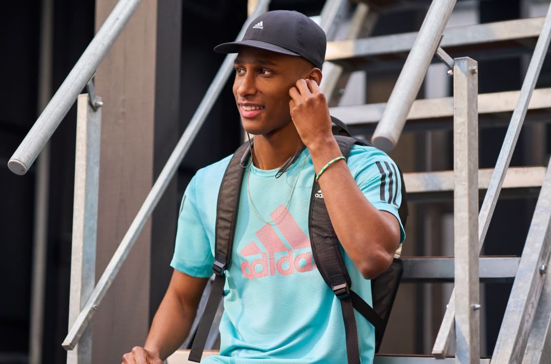 Man wearing blue adidas t-shirt listening to music through headphones, adidas, sports, lifestyle, activewear