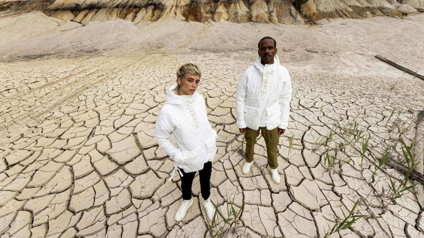 Two people stand in dry landscape wearing adidas Terrex gear.