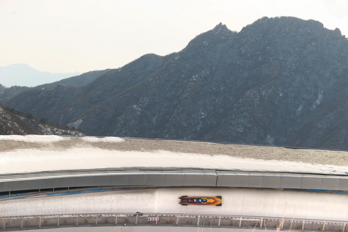 Bobsled on ice-track in a mountain region at the Beijing Olympics