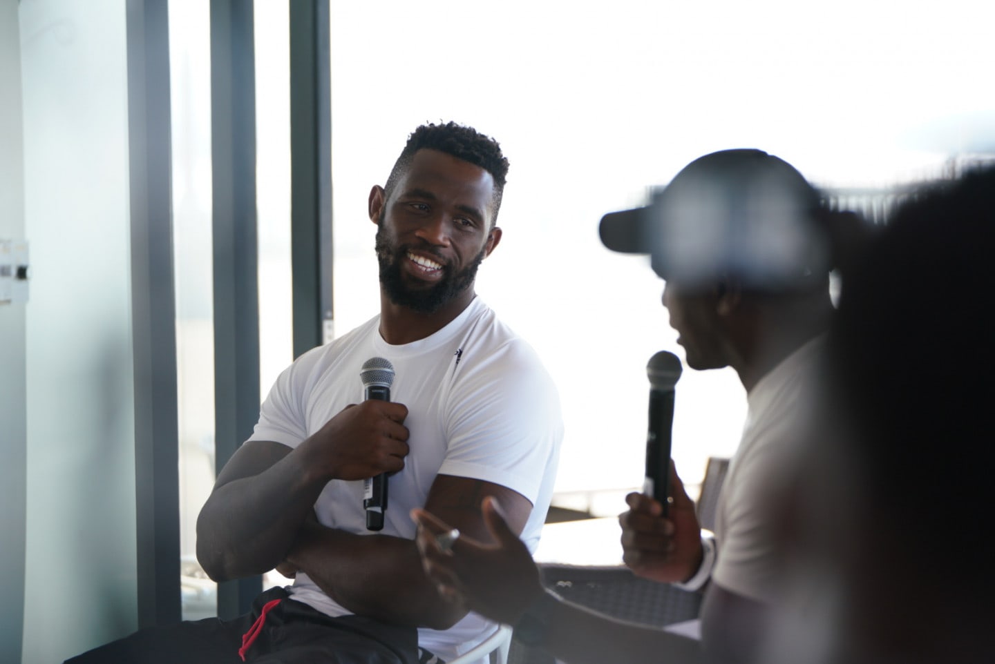 Siya Kolisi speaking with a microphone.