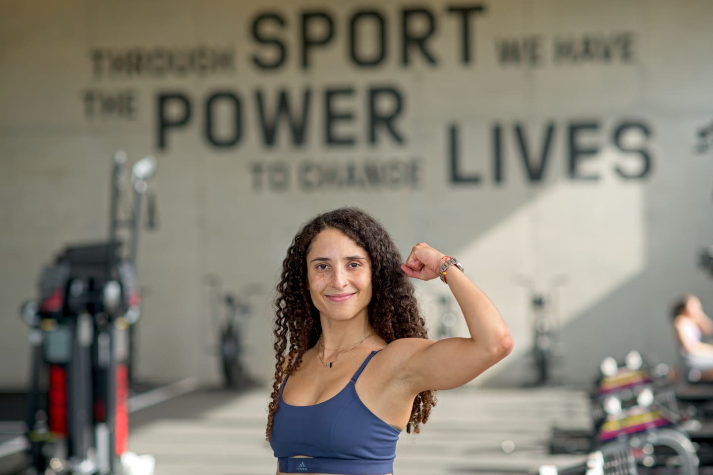 Woman flexing her muscles at the gym
