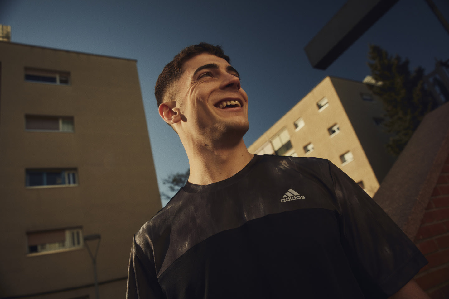 Person wearing a black adidas shirt smiling