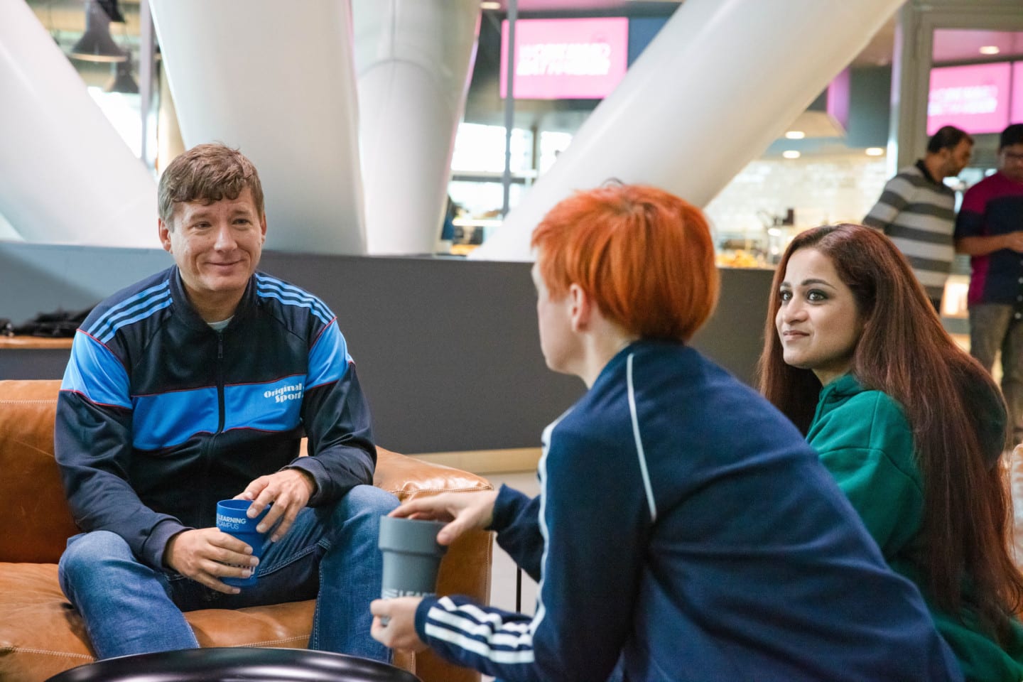 Three adidas employees having coffee and chatting.