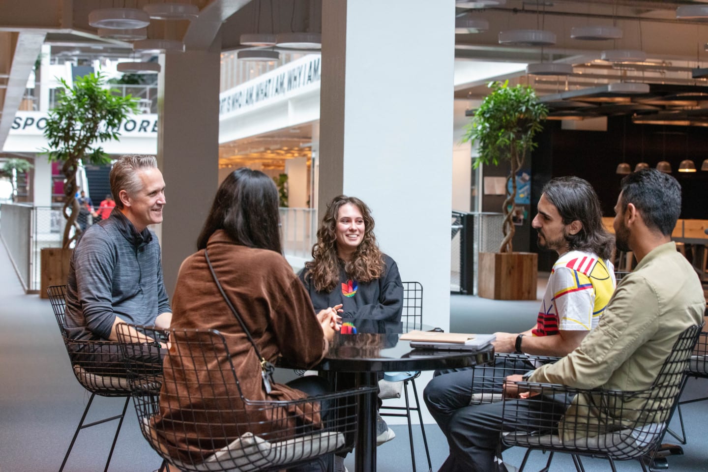 adidas employees working together around a coffee table.