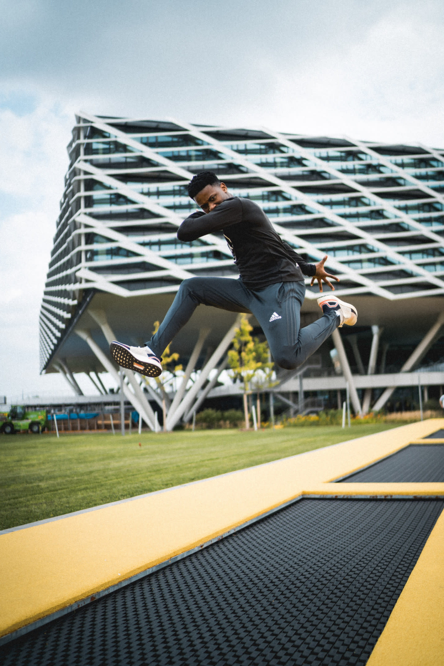 Man jumping on trampoline outside of adidas HQ.