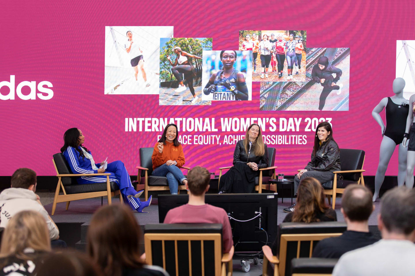 Four women sit on stages at an international women's day event.