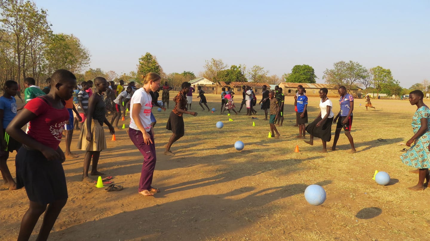 A group of people perform football drills.