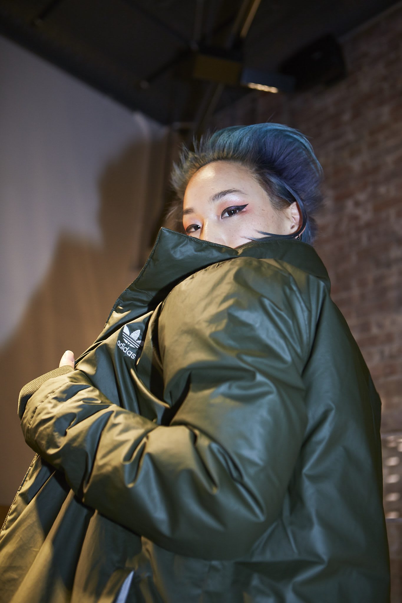 woman looking over shoulder covered by jacket creators in NYC