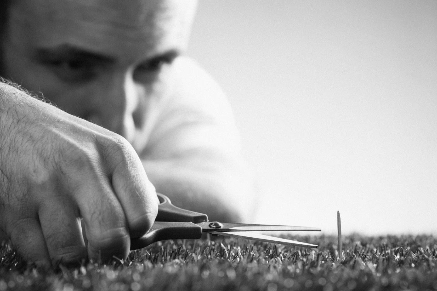 man cutting single grass blade successful habit change