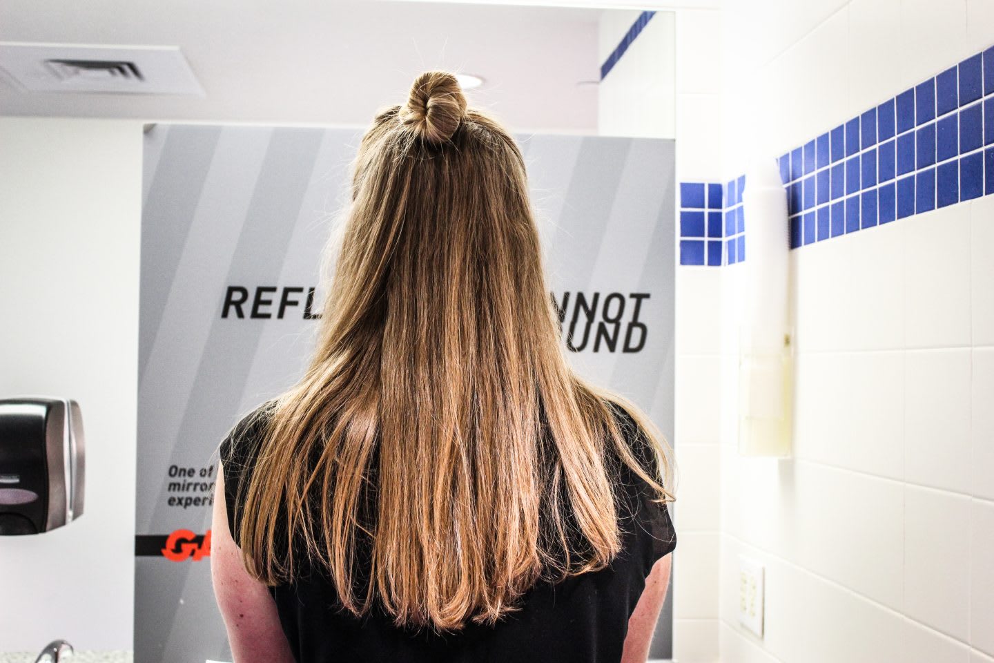 girl from the back looking into a covered mirror, mirror-free, girl standing in the restroom