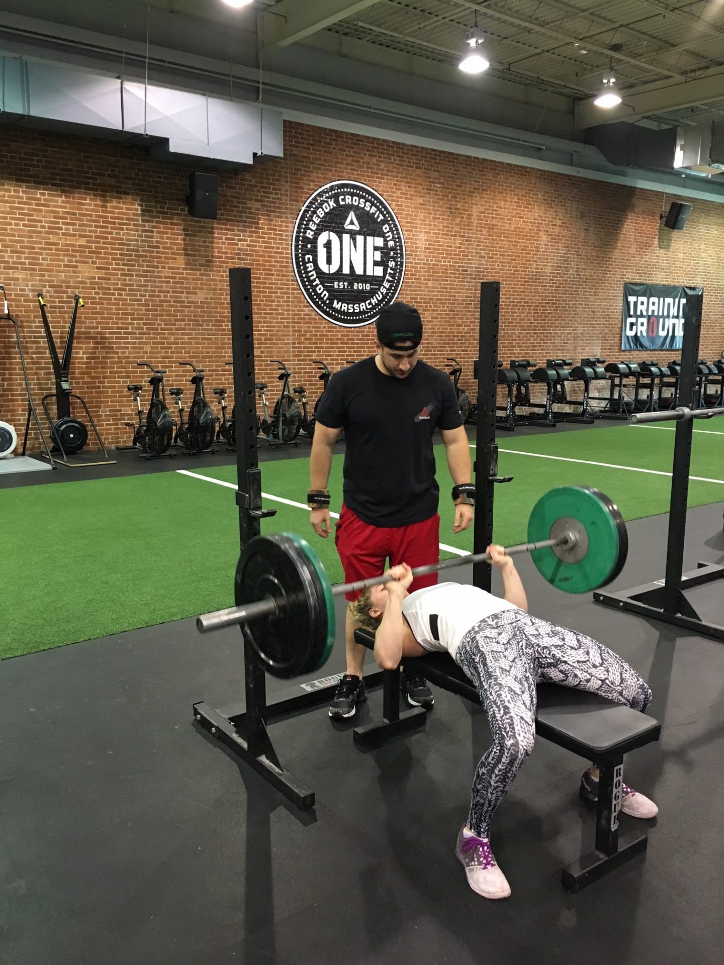 woman lifting weight with fitness trainer why women should go to the weight room
