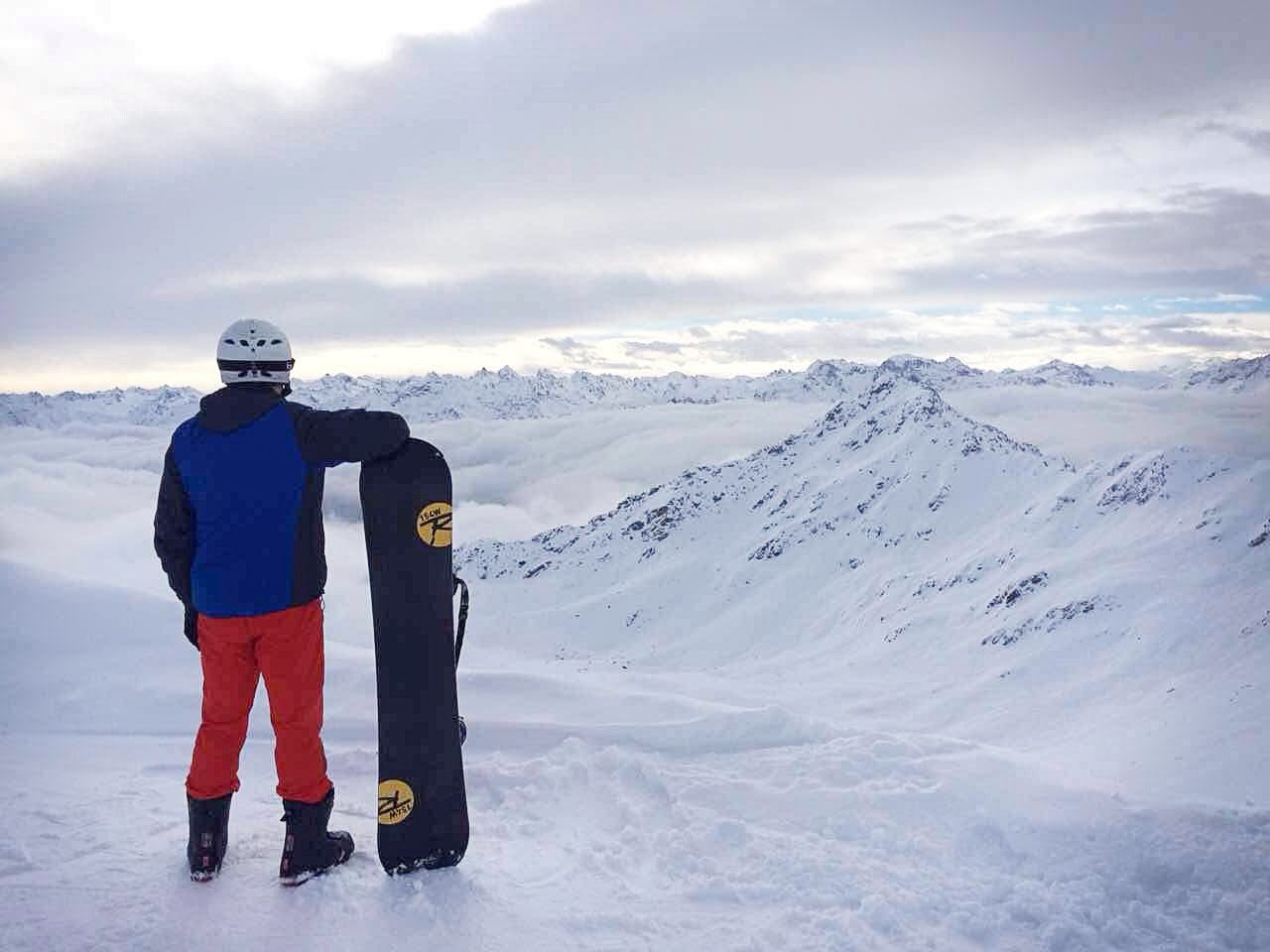 Snowboarder looking over mountains working abroad dream career