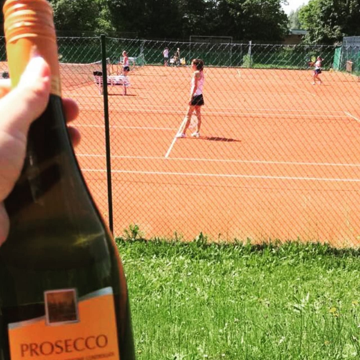 Prosecco in in front of a tennis court