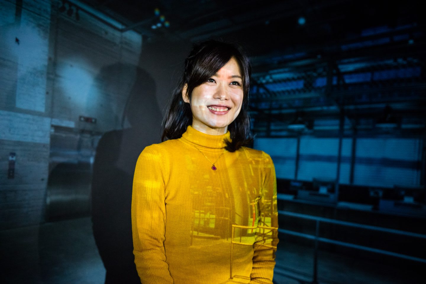 Woman smiling with a projection behind her