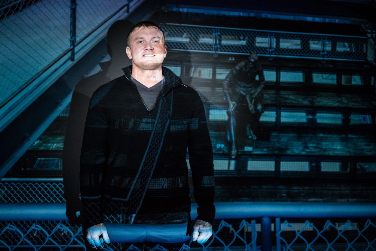 Man smiling with a projection behind him